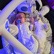 Austin is registered to the contest to win money with this photo: animal, baby, baby_toys, blanket, blue_light, cat, child, comfort, cozy, cute, fluffy_cat, indoor, infant, lying_down, pacifier, pet, purple_light, resting, sleepy, soft_texture