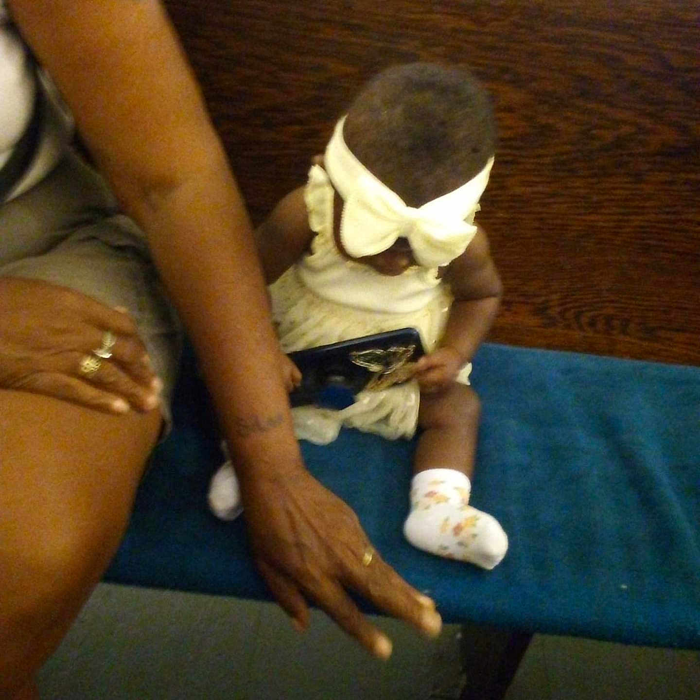 A Maricle joined the competition — help win amazing prizes! adult, arm, baby, bench, bow_headband, child, clothing, dress, floor, furniture, hand, indoor, object, person, ring, seated, skin, socks, tattoo, wood