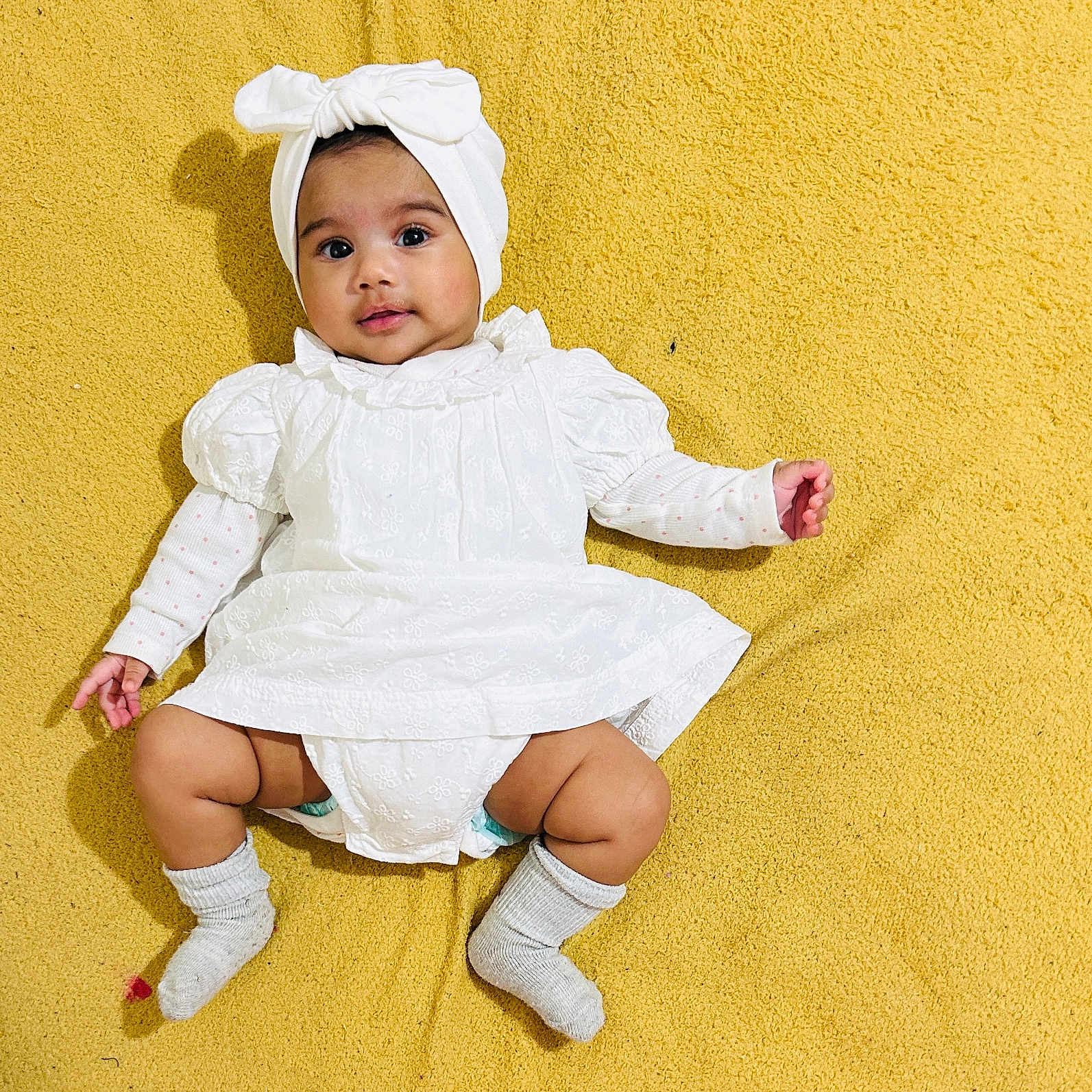 Sheron joined the competition — help win amazing prizes! baby, bodypart, bonnet, cap, clothing, diaper, dress, face, finger, hand, happy, hat, head, hosiery, person, photography, portrait, sitting, smile, sock