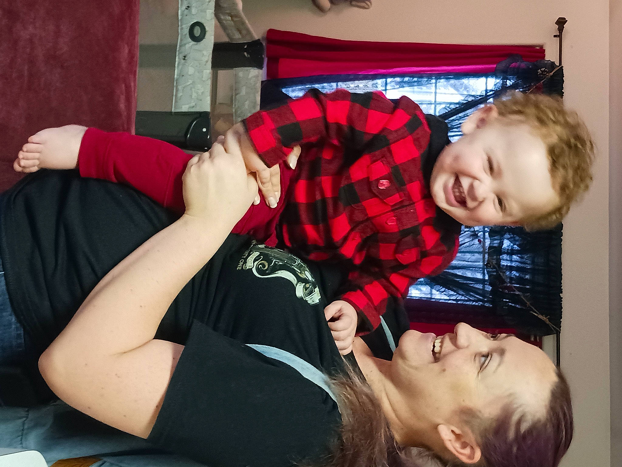 Jason is registered to the contest to win money with this photo: child, comfort, elbow, fun, gesture, happy, human_leg, joint, joy, knee, lap, person, plaid, red, sitting, sleeve, smile, t_shirt, tartan, thigh