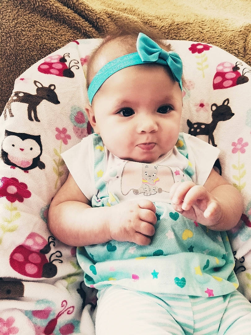 Julie is registered to the contest to win money with this photo: baby, baby_products, baby_toddler_clothing, cheek, child, daughter, hair_accessory, headgear, person, pink, product, skin, toddler