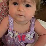 Charleigh Bloom is registered to the contest to win money with this photo: baby, child, high_chair, purple_outfit, bow, butterfly, curly_hair, indoor, cute, looking_at_camera, infant, young_child, portrait, skin, face, hand, sitting, clothing, expression, person