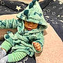 Eli joined the competition — help win amazing prizes! baby, child, hoodie, dinosaur, plush, blanket, striped_pants, socks, indoor, cute, cozy, soft, star_pattern, infant, sitting, clothing, face, expression, home, comfortable