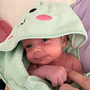 Liam joined the competition — help win amazing prizes! baby, infant, towel, hood, cute, soft, skin, hand, finger, person, child, newborn, indoors, closeup, expression, face, gaze, comfort, care, blanket