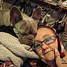 Smokey is registered to the contest to win money with this photo: woman, dog, french_bulldog, glasses, blanket, indoor, couch, face, pet, snuggling, hand, ring, nail, sitting, relaxed, cozy, home, portrait, casual, comfort