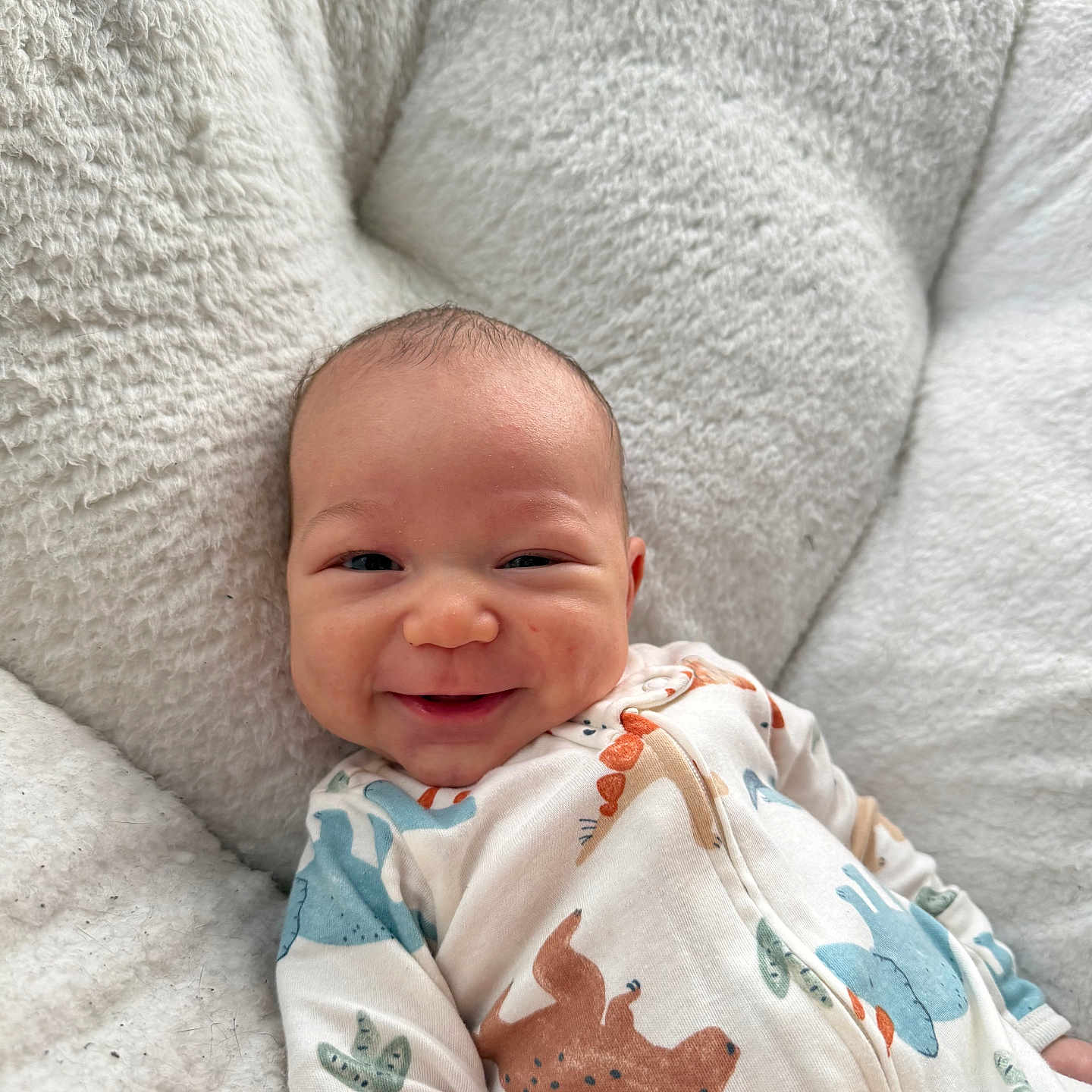 Jaylen joined the competition — help win amazing prizes! baby, smiling, infant, onesie, animal_print, cushion, cozy, happy, face, child, cute, soft_texture, indoors, portrait, young_child, comfort, relaxing, sleepwear, person, closeup