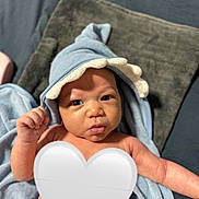 Jaylen joined the competition — help win amazing prizes! baby, infant, towel, blue, hood, blanket, diaper, skin, face, hand, expression, cute, newborn, lying_down, indoors, soft_texture, cozy, small, portrait, child