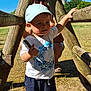 toddler, child, cap, tshirt, shorts, stick, wooden_structure, playground, adult, sunglasses, grass, outdoor, sunlight, shadow, summer, nature, person, exploration, fun, daytime