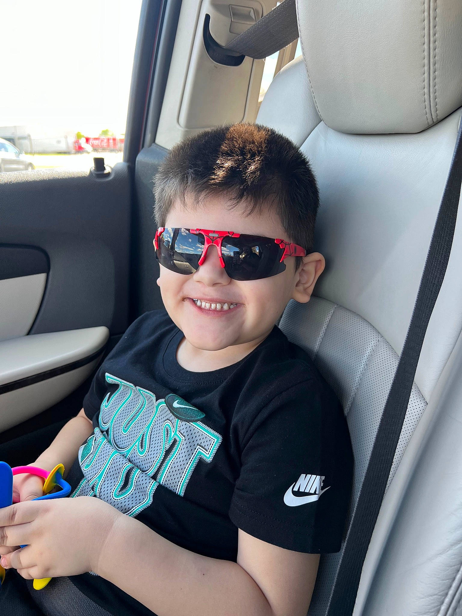 Fernando is registered to the contest to win money with this photo: auto_part, automotive_design, automotive_exterior, car, car_seat, car_seat_cover, eyewear, glasses, goggles, head_restraint, joy, motor_vehicle, person, seat_belt, smile, sunglasses, t_shirt, toddler, vehicle, vehicle_door