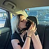 affection, animal, backseat, black_cat, car_interior, casual_clothing, cat, daylight, hand, human, kiss, pet, platinum_blonde_hair, seat, short_sleeve_shirt, shorts, sunlight, transportation, window, woman