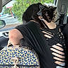 Ryú is registered to the contest to win money with this photo: animal, bag, black_cat, black_shirt, bow_tie, braided_hair, car_interior, car_seat, casual, cat, cutout_shirt, daylight, greenery, indoor, leopard_print, parked_cars, person, pet, shoulder, window