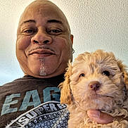 Gemini joined the competition — help win amazing prizes! background, closeup, curly_fur, cute, dog, earring, face, happy, head, holding, human, indoor, light, man, pet, portrait, puppy, smile, texture, tshirt