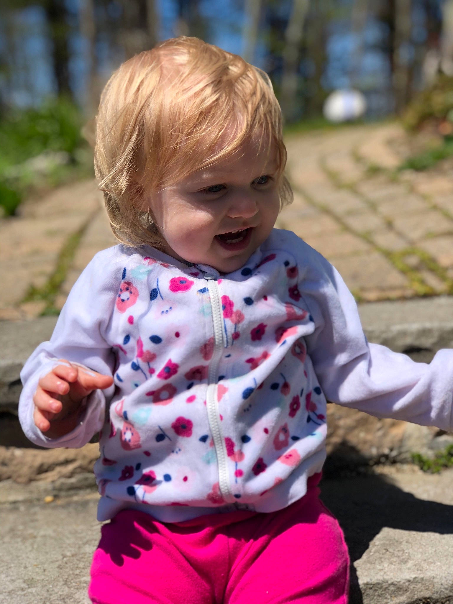 Memphis is registered to the contest to win money with this photo: baby, child, grass, outerwear, pattern, person, pink, play, recreation, sitting, skin, sleeve, smile, toddler, tree, vacation