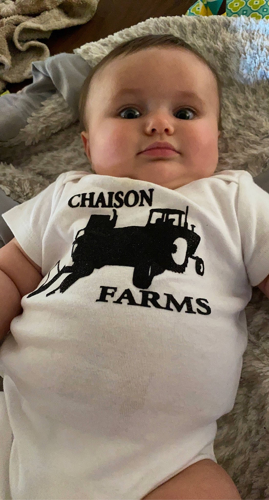 Blair is registered to the contest to win money with this photo: baby_toddler_clothing, cool, eye, face, facial_expression, gesture, grey, hairstyle, happy, head, human, mammal, neck, outerwear, person, sleeve, t_shirt, toddler, tree, vertebrate