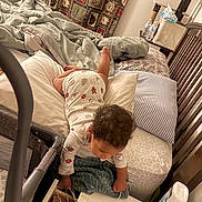 Michael is registered to the contest to win money with this photo: baby, bed, bedroom, blanket, child, clothing, cozy, curious, curly_hair, furniture, home, indoor, nightstand, pajamas, person, pillow, reaching, table, toddler, water_bottle
