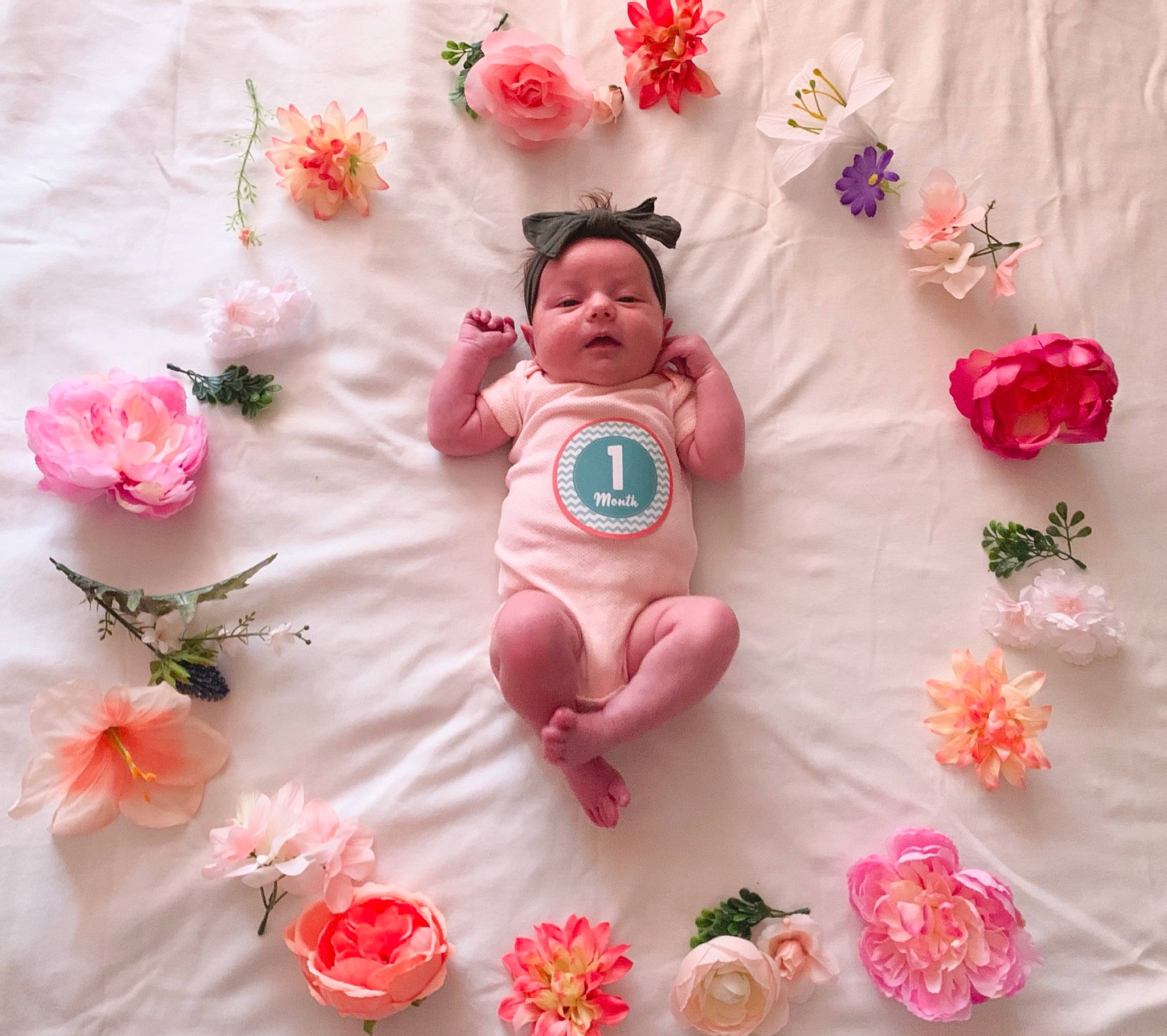 Gloria Grace is registered to the contest to win money with this photo: baby, baby_products, baby_toddler_clothing, cake_decorating_supply, craft, cut_flowers, fashion_accessory, floral_design, happy, head, linens, magenta, pattern, peach, person, petal, pink, plant, sugar_cake, sweetness