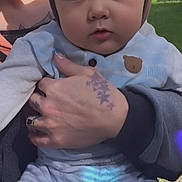 Ryker joined the competition — help win amazing prizes! baby, child, hat, animal_hat, blue_clothing, striped_pants, tattoo, hand, adult, outdoor, grass, nature, holding, portrait, cute, person, face, expression, sunlight, casual