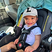 Enzo joined the competition — help win amazing prizes! toddler, child, car_seat, cap, smile, baby, safety_harness, car_interior, seat, white_clothing, happy, young_child, sunlight, cute, portrait, infant, seatbelt, headwear, vehicle, baby_seat