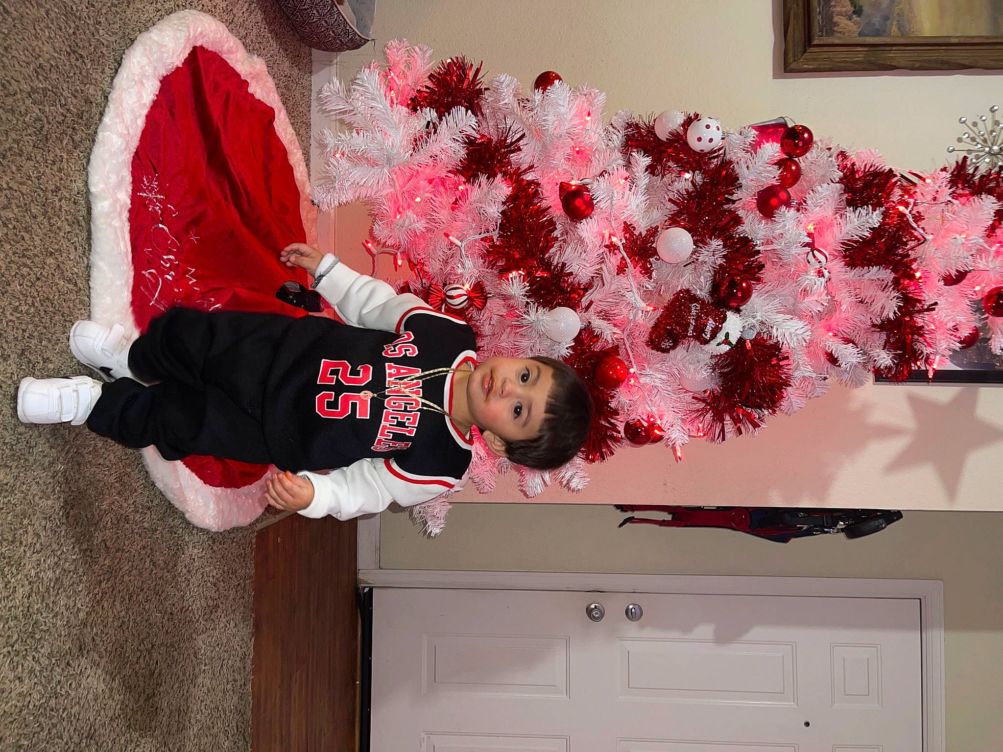 Angel is registered to the contest to win money with this photo: cabinetry, carmine, christmas, christmas_decoration, christmas_eve, christmas_ornament, cupboard, drawer, event, happy, holiday, magenta, ornament, person, picture_frame, red, room, t_shirt, textile, toddler