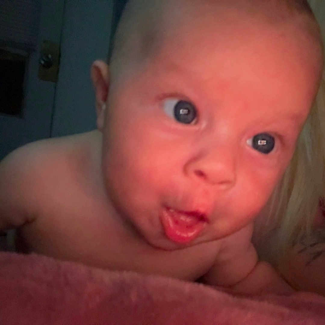 Willow joined the competition — help win amazing prizes! arm, baby, child, closeup, curious, cute, expression, face, human, indoor, infant, lying_down, mouth_open, person, pink_blanket, portrait, skin, soft_texture, tattoo, wide_eyes