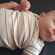 Hudson is registered to the contest to win money with this photo: baby, baby_garment, child, chubby_cheeks, clothing, curious, cute, face, fist, head, indoors, infant, lying_down, newborn, person, portrait, relaxed, skin, soft_light, striped_onesie