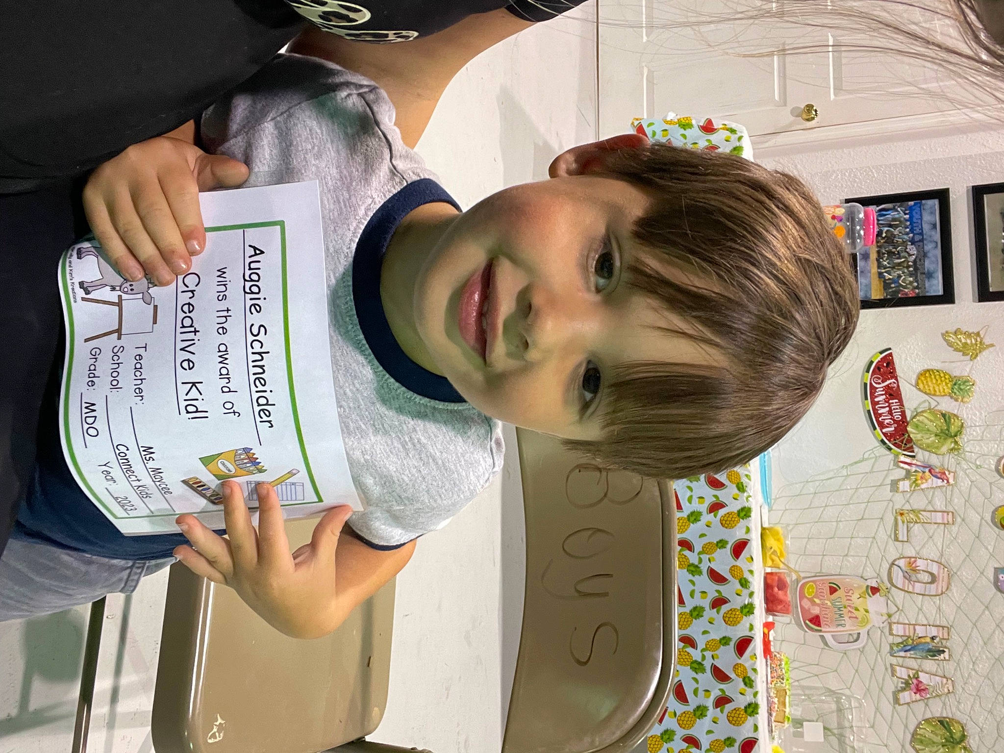 August is registered to the contest to win money with this photo: child, eyewear, fun, happy, hat, joy, pattern, person, publication, reading, room, sleeve, smile, t_shirt, visual_arts, writing