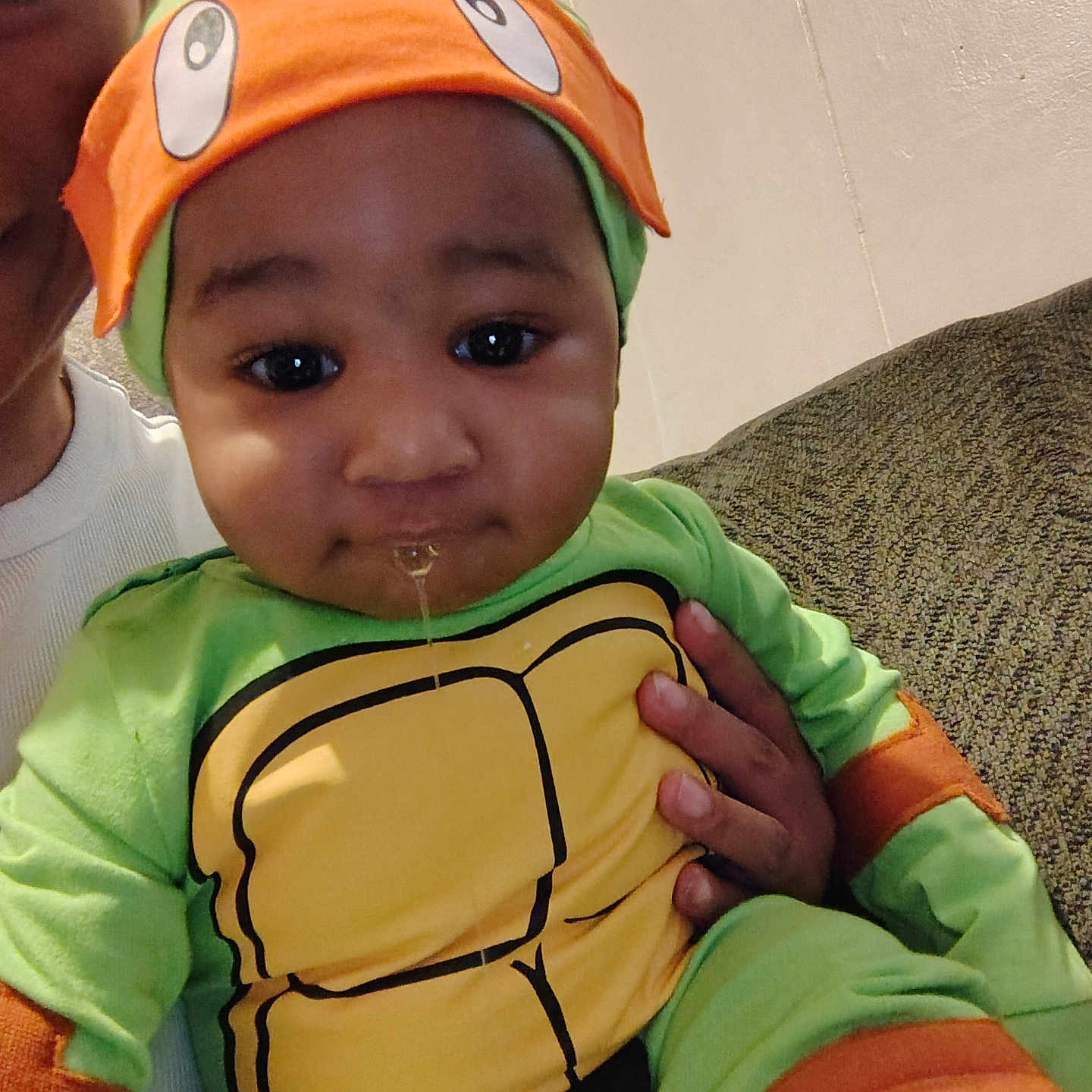 Micha is registered to the contest to win money with this photo: baby, baseballcap, bodypart, bonnet, cap, clothing, coat, couch, face, finger, furniture, hand, happy, hat, head, jacket, person, photography, portrait, t_shirt