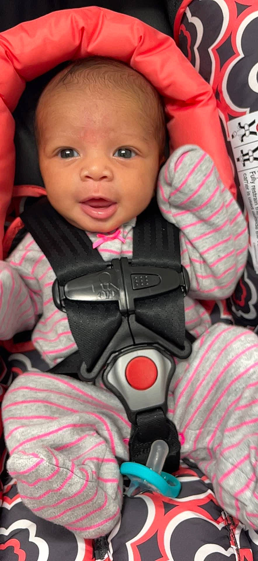 Marleah is registered to the contest to win money with this photo: baby, baby_toddler_clothing, carmine, cheek, child, comfort, gesture, happy, microphone, nail, pattern, person, personal_protective_equipment, pink, red, sitting, skin, sleeve, smile, thumb