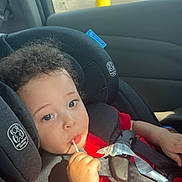 Zyaire joined the competition — help win amazing prizes! toddler, child, car_seat, red_shirt, lollipop, curly_hair, seatbelt, car_interior, window, daylight, parking_lot, blue_sky, sunlight, safety, young_child, portrait, cute, baby, seat, vehicle