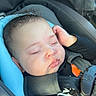Zyaire is registered to the contest to win money with this photo: baby, sleeping, car_seat, child, infant, curly_hair, black_clothing, straps, seatbelt, peaceful, closed_eyes, hand, head, young_child, resting, indoors, portrait, safety_harness, cute, soft_light