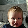 baby, child, infant, portrait, sitting, couch, indoors, home, face, smiling, happy, blue_shirt, blond_hair, short_hair, eyes, nose, mouth, sunlight, close_up, photography