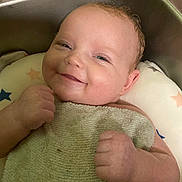 Ellie is registered to the contest to win money with this photo: baby, infant, towel, sink, bath, smile, face, hand, skin, water, cushion, star_pattern, happy, relaxing, indoors, cute, child, person, head, expression