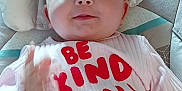 Aurora joined the competition — help win amazing prizes! baby, infant, smiling, pink_clothing, text_on_clothing, cushion, seat, hand, face, cheerful, indoors, child, cute, gesture, happy, young, person, closeup, apparel, message