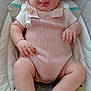 Aurora is registered to the contest to win money with this photo: baby, infant, smiling, tongue_out, knitted_clothing, romper, cushion, baby_seat, cute, chubby_cheeks, playful, child, person, indoors, comfort, skin, legs, hands, head, portrait
