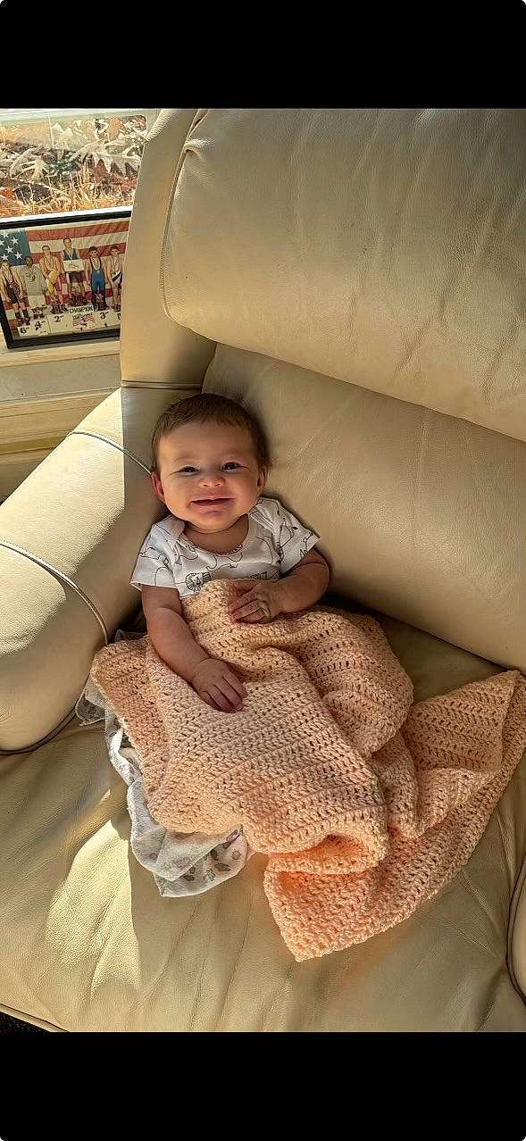 Lara joined the competition — help win amazing prizes! automotive_exterior, baby, baby_toddler_clothing, car_seat, chair, child, comfort, dress, finger, flooring, fun, human_leg, joy, leg, pattern, person, sitting, skin, smile, thigh