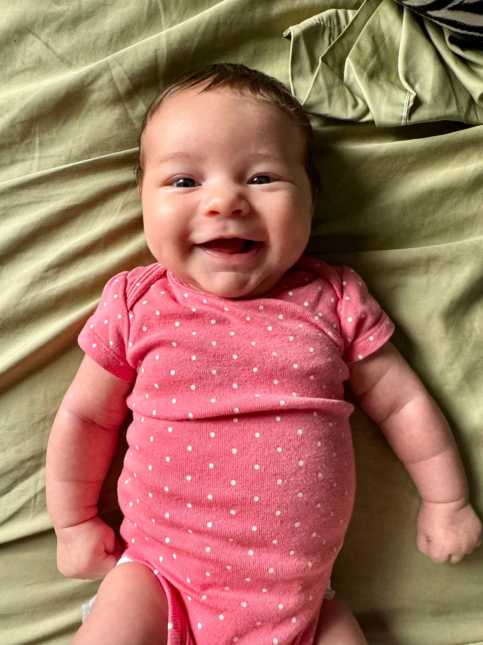 Lara is registered to the contest to win money with this photo: baby, baby_toddler_clothing, cheek, chin, eye, facial_expression, gesture, happy, human, iris, joy, lip, mouth, neck, nose, person, pink, product, skin, sleeve