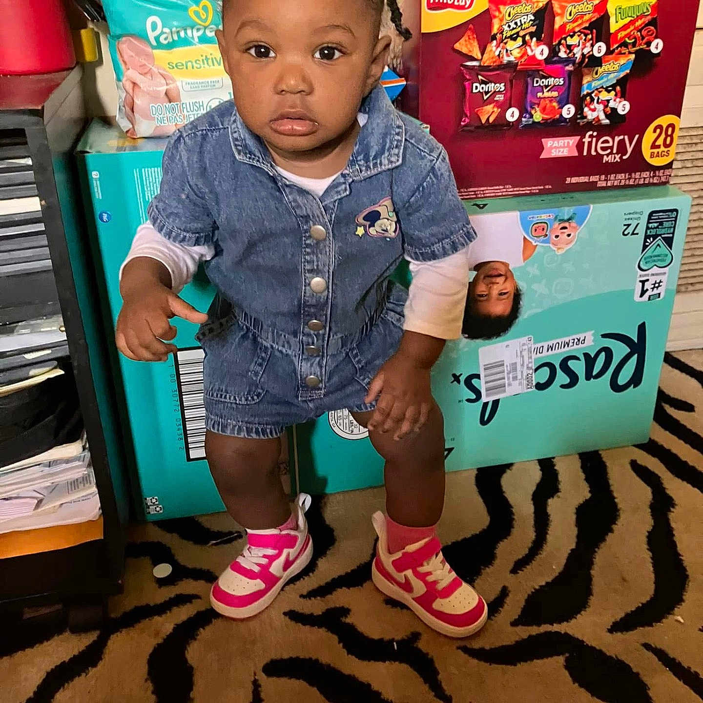 Keyunna joined the competition — help win amazing prizes! carpet, child, clothing, curious, denim, face, floor, hair, household_items, indoor, person, photography, pink_sneakers, romper, room, snack_boxes, socks, standing, toddler, zebra_pattern