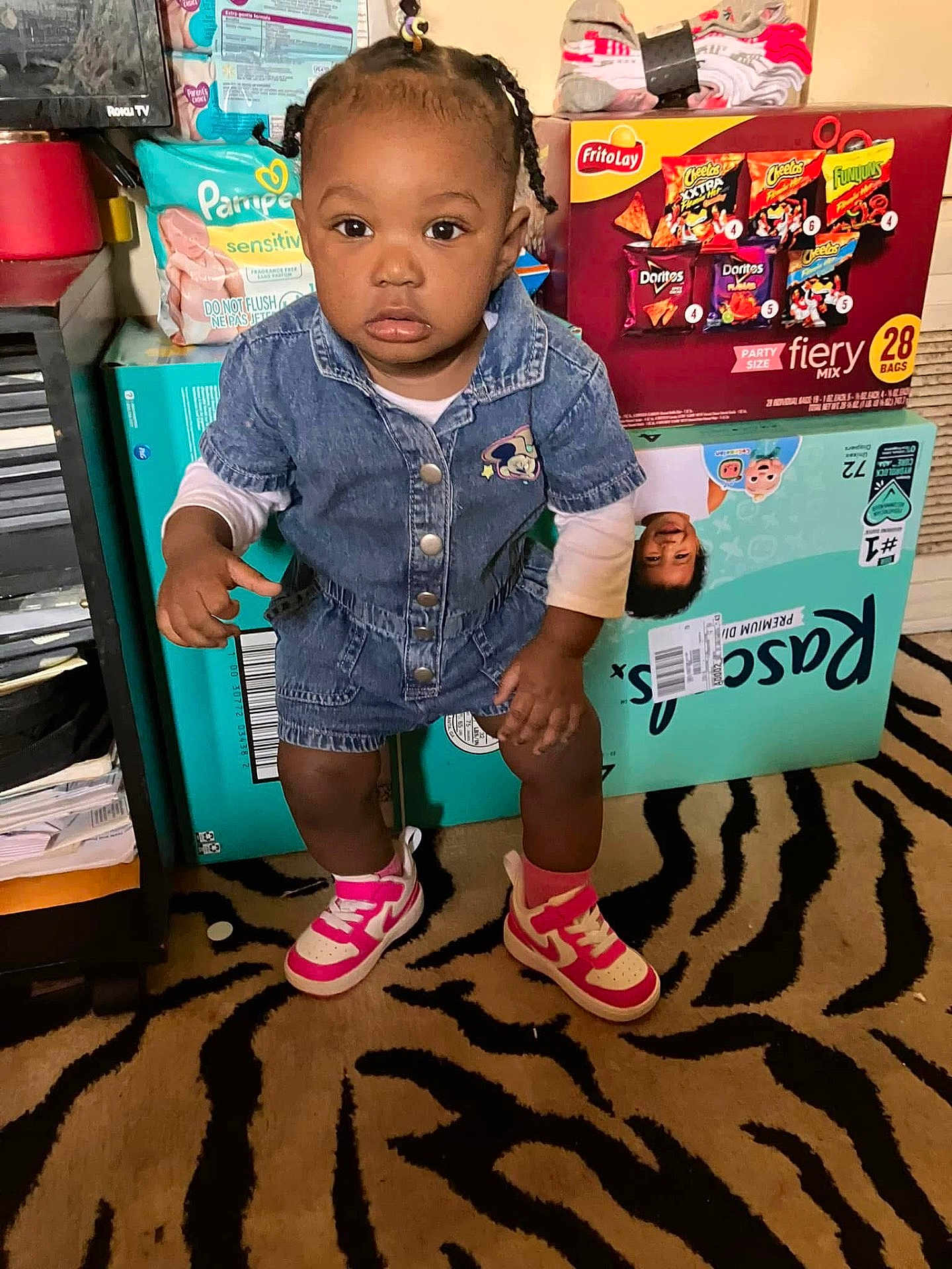 Keyunna joined the competition — help win amazing prizes! toddler, child, denim, romper, pink_sneakers, carpet, zebra_pattern, snack_boxes, household_items, indoor, curious, standing, clothing, face, person, floor, socks, hair, room, photography