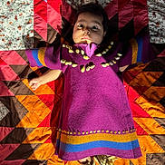 Zalina Mia joined the competition — help win amazing prizes! baby, child, purple_dress, shell_decorations, quilt, patchwork, colorful, moccasins, footwear, indoor, portrait, laying_down, wide_eyes, curious_expression, fabric, pattern, textile, hand, face, person