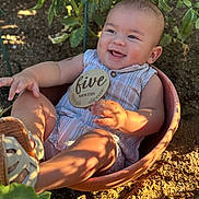 Dono Akai joined the competition — help win amazing prizes! baby, infant, child, flower_pot, outdoor, garden, soil, plants, greenery, sunlight, shadow, smiling, holding, sign, wooden_sign, sitting, cute, summer, clothing, footwear