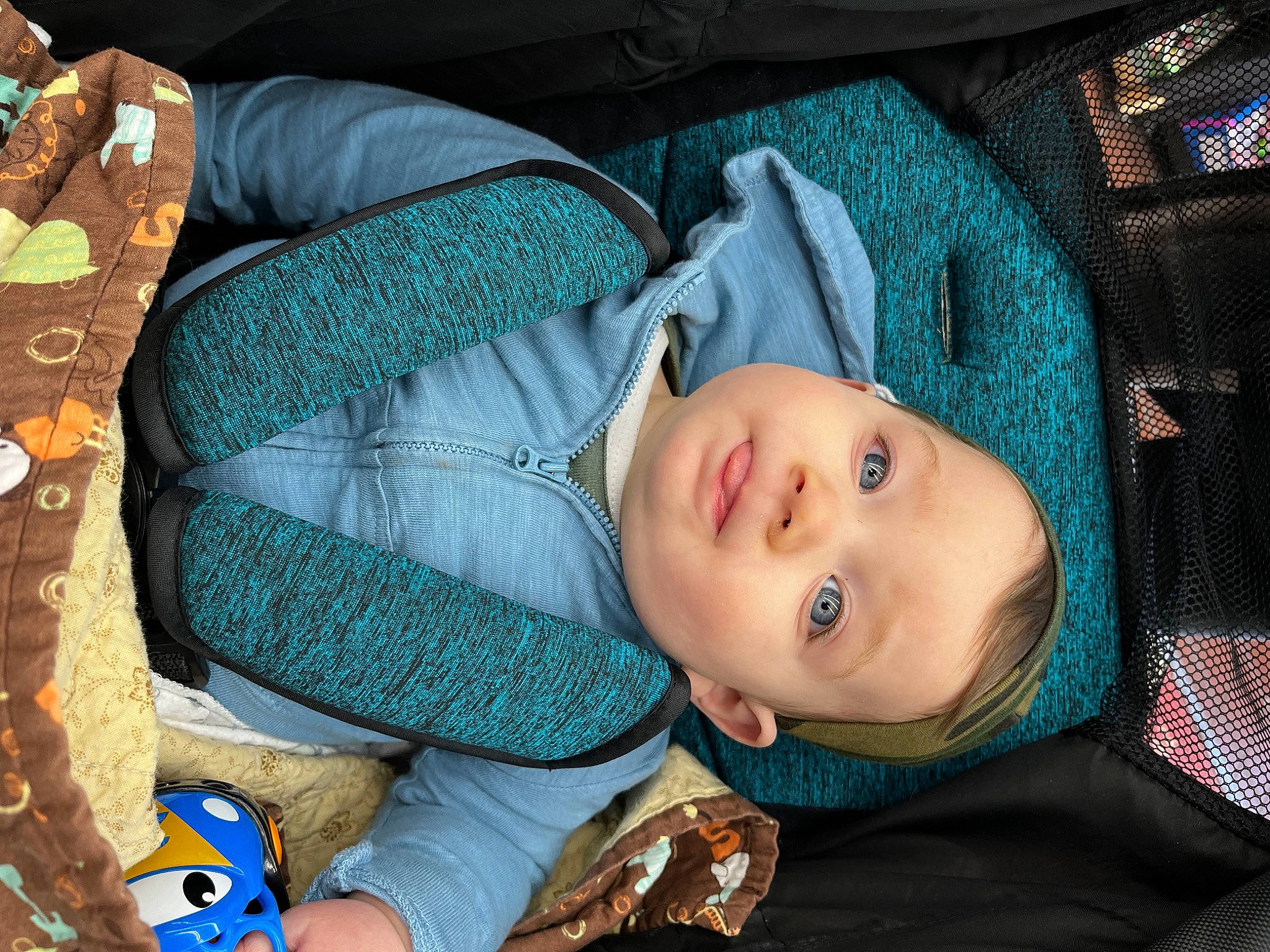 Casey is registered to the contest to win money with this photo: azure, baby, car_seat, chair, cheek, child, comfort, cool, doll, electric_blue, fun, linens, mouth, pattern, person, product, room, sitting, textile, toddler