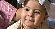 Violet is registered to the contest to win money with this photo: baby, child, headband, bow, smile, face, clothing, infant, cute, portrait, indoors, blanket, person, young_child, sitting, soft_lighting, apparel, expression, headwear, closeup
