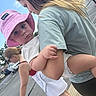 baby, bucket_hat, casual, child, clothing, curious, daylight, family, hand, holding, outdoor, people, person, pink_hat, side_view, street, urban, walking, woman, young_child