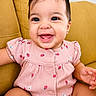 baby, child, smiling, pink_clothing, strawberry_pattern, couch, yellow_couch, happy, portrait, indoor, cute, infant, sitting, face, person, young_child, adorable, cheerful, skin, short_hair
