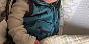Caleb is registered to the contest to win money with this photo: baby, sleeping, blanket, vest, animal_print, baby_seat, cozy, infant, child, peaceful, soft_texture, cushion, clothing, nap, indoor, portrait, cute, resting, newborn, comfort