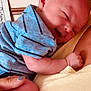 Caleb is registered to the contest to win money with this photo: baby, infant, blue_clothing, striped_onesie, sleepy, smiling, newborn, human, person, holding, hand, foot, skin, indoor, home, closeup, cute, soft_light, tender, affection
