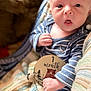 Caleb joined the competition — help win amazing prizes! baby, infant, one_month, milestone_card, striped_clothing, blue_onesie, blanket, knitted_blanket, face, hand, curious_expression, portrait, indoor, cute, child, newborn, soft_lighting, close_up, person, sitting