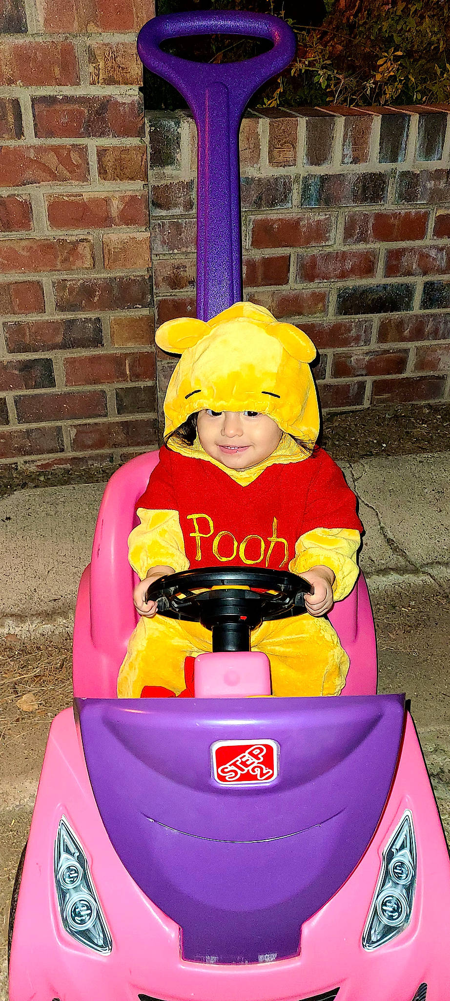 Leah is registered to the contest to win money with this photo: automotive_design, automotive_exterior, automotive_tire, blue, brick, brickwork, bumper, carmine, child, costume_hat, fun, headwear, joy, magenta, motor_vehicle, person, personal_protective_equipment, recreation, red, riding_toy