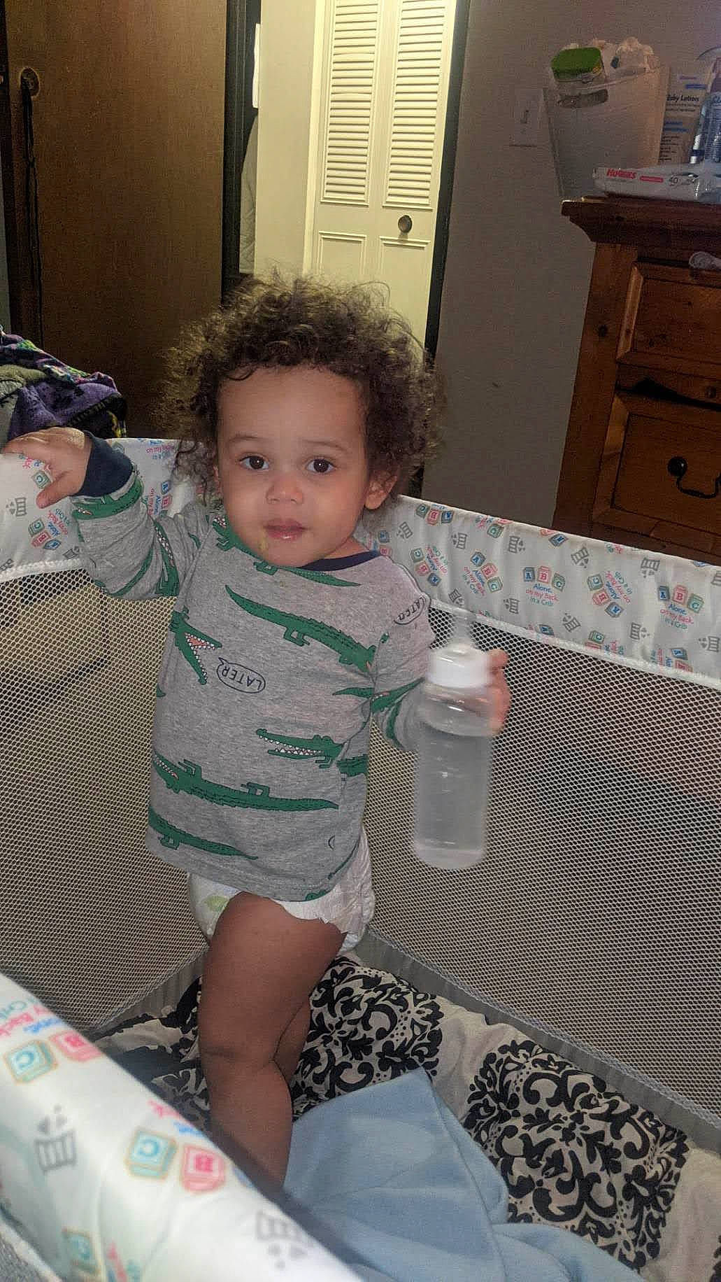 Cyrus is registered to the contest to win money with this photo: baby, baby_toddler_clothing, black, bottle, child, drawer, floor, flooring, fun, hairstyle, happy, iris, mammal, people, person, plastic_bottle, sitting, skin, smile, toddler