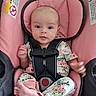 baby, infant, car_seat, pink, floral_clothing, foot, hand, face, child, seatbelt, safety, cute, looking_at_camera, indoors, apparel, newborn, person, child_seat, fabric, resting